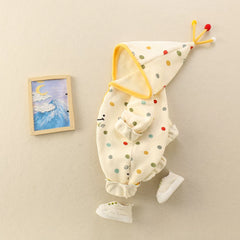 Side view of cream polka dot baby romper with white shoes